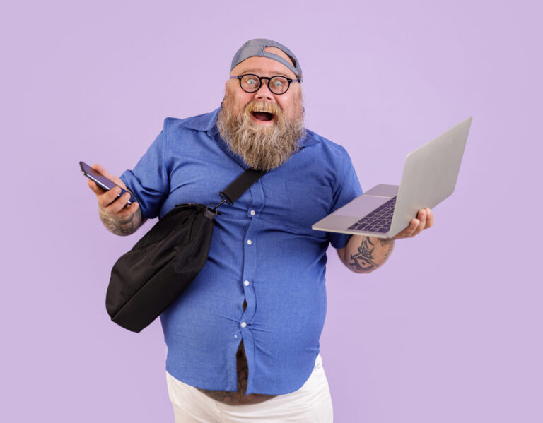 Mann mit Laptop und Handy in der Auftragsvorbereitung